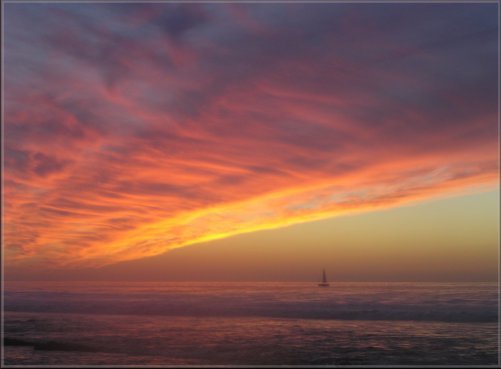illumined clouds, boat on ocean